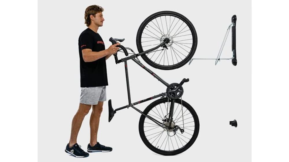 A bike being placed in to a wall rack